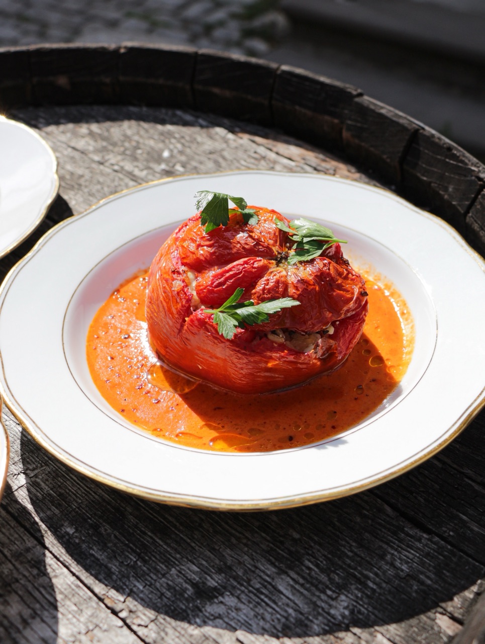 Gefüllte Paprika in Paprikasauce auf einem Weinfass serviert